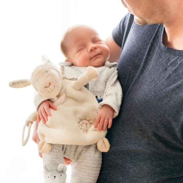 Fehn Schmusetuch Schaf mit einem schlafenden Baby